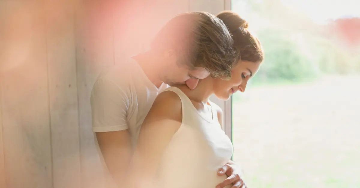 Fertility evaluation for males shown through a tender embrace of a couple during early pregnancy.