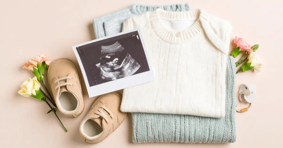 Fertility experts showcasing an ultrasound image, baby clothes, and baby shoes arranged for a pregnancy announcement.