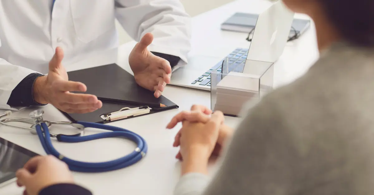 Myomectomy for fertility explained during a detailed consultation between a doctor and patient at a clinical desk.