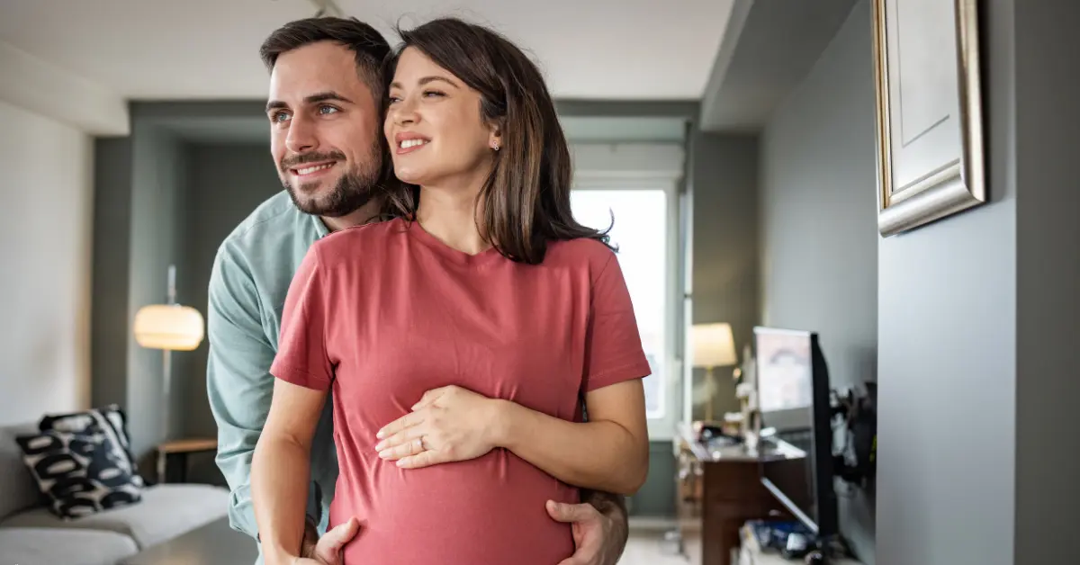 Intrauterine insemination process success shown by a happy couple embracing at home during pregnancy.