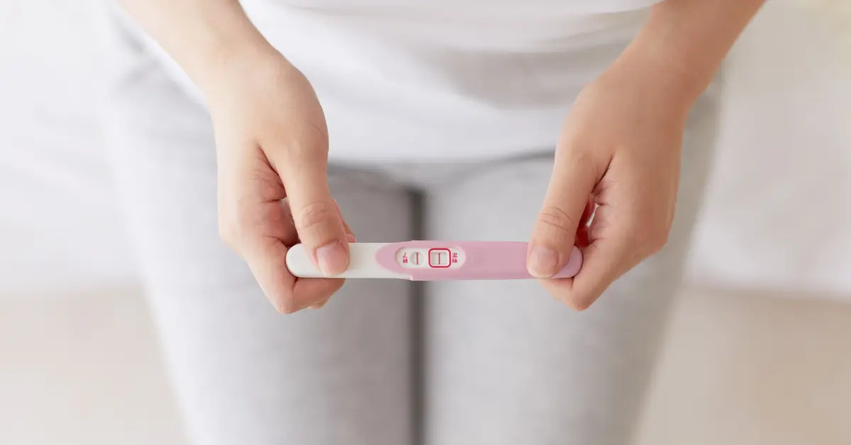 Managing fertility treatment shown with a woman holding a negative pregnancy test result in both hands.