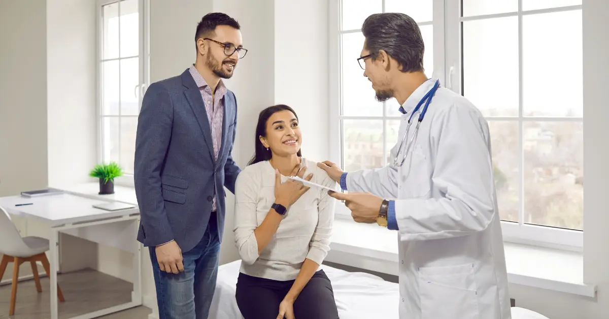 Fertility treatment options discussed between a couple and doctor in a bright, modern medical office.