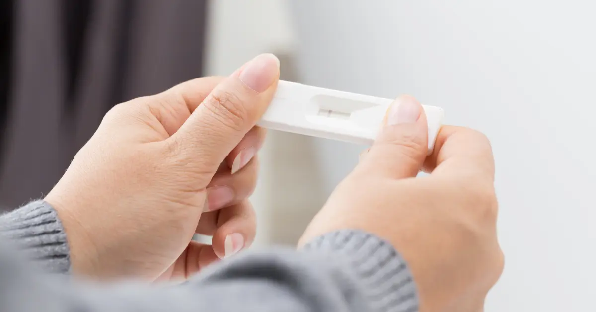Surgical options for infertility implied as a person examines a faint result on a pregnancy test.